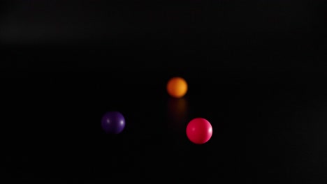 three balls bouncing against a dark background