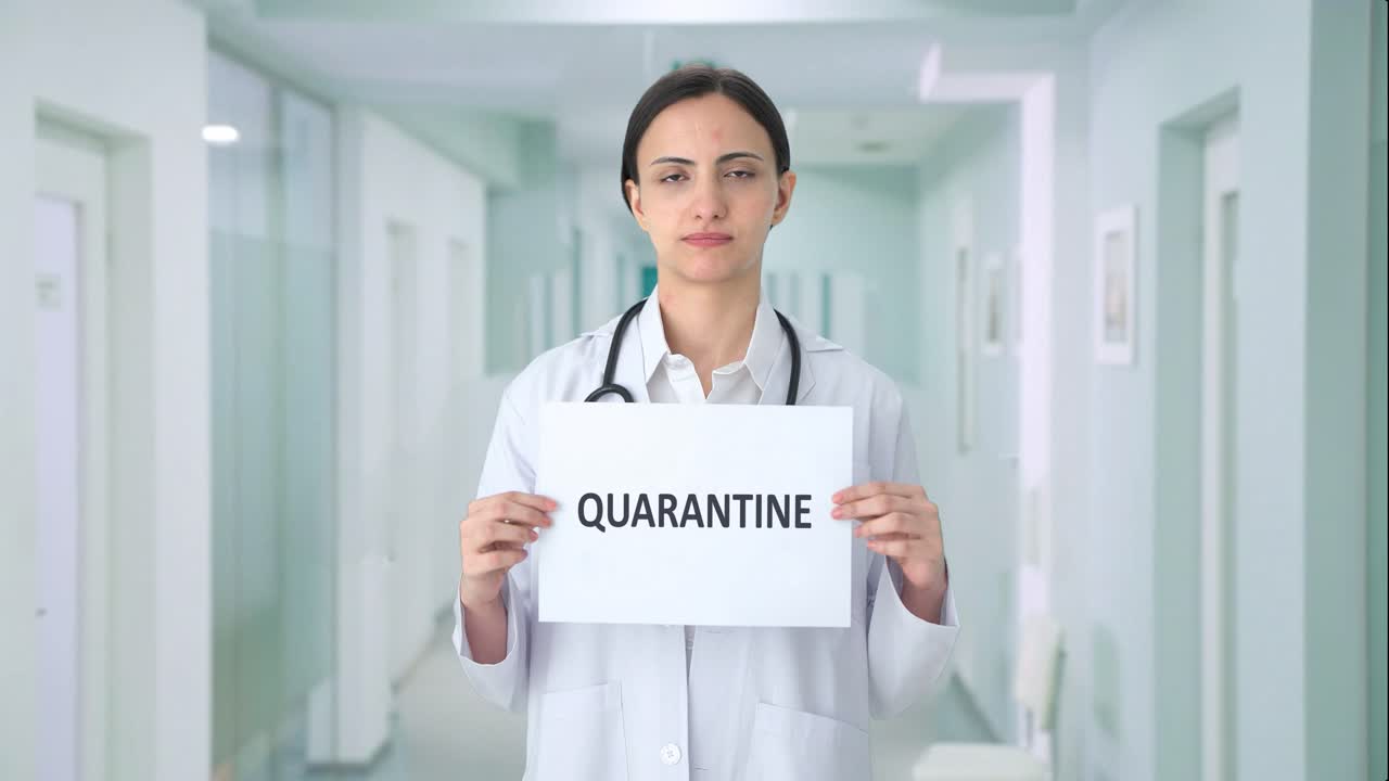 Dottoressa indiana triste che espone un cartello QUARANTENA