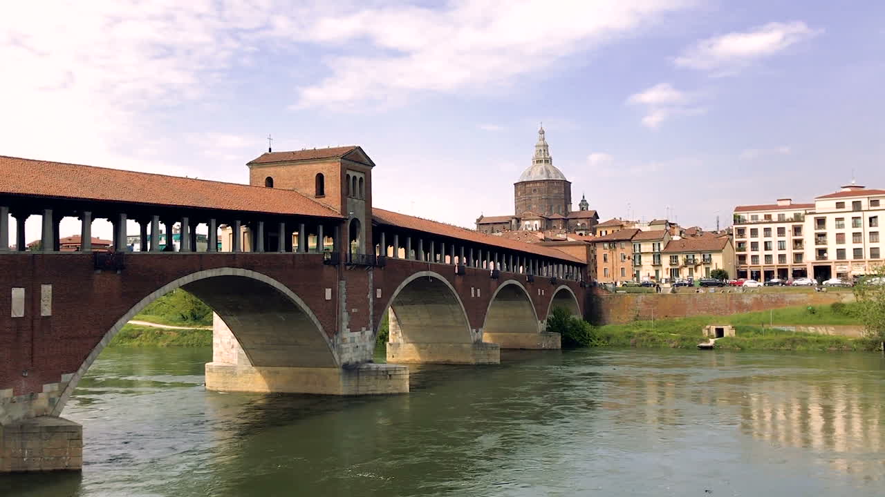 Ponte coperto sul fiume Ticino a Pavia, Italia, con cattedrale sullo sfondo