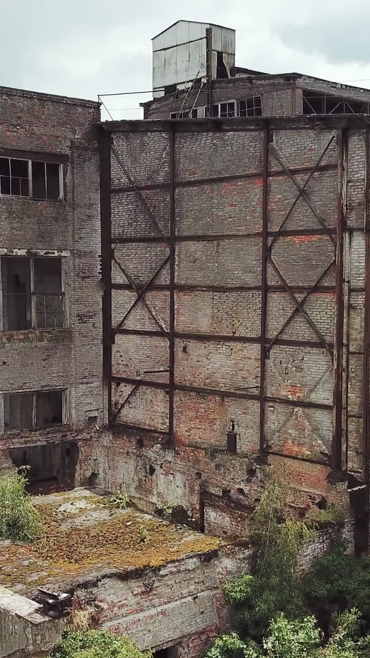 Ruins of an old factory. Old industrial building for demolition. Aerial view. Vertical video