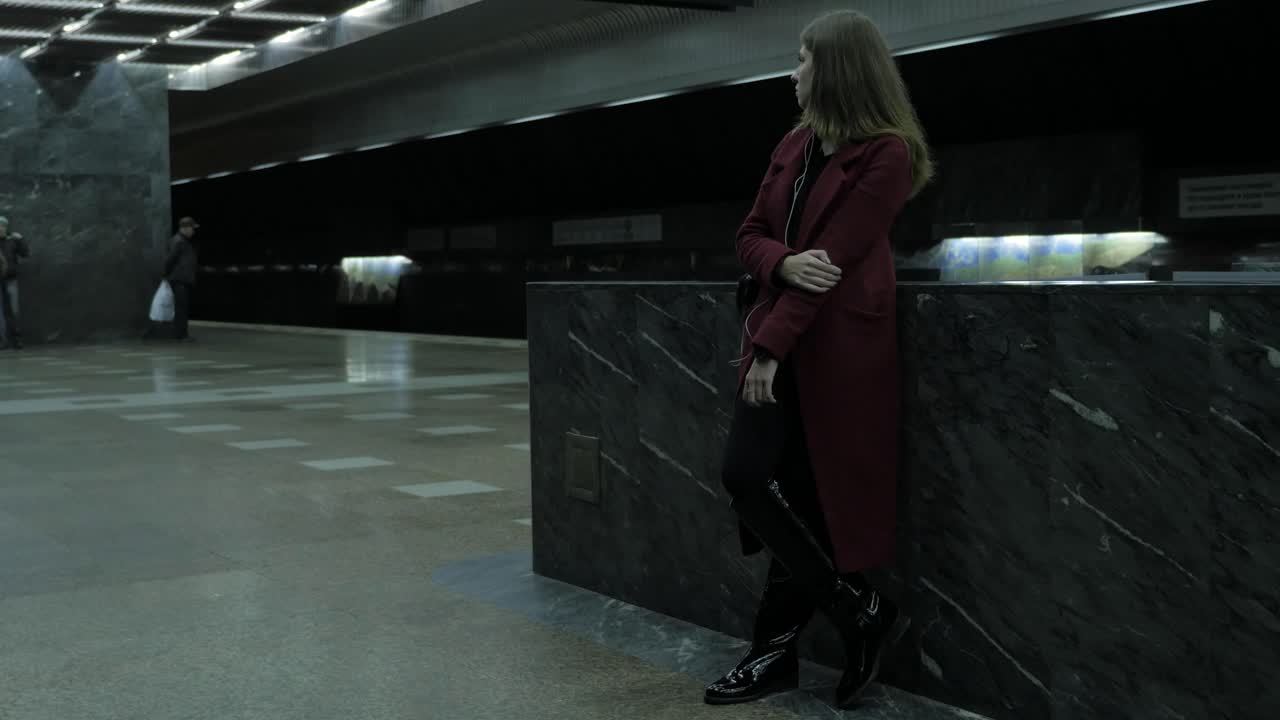 mujer esperando en una estación de metro