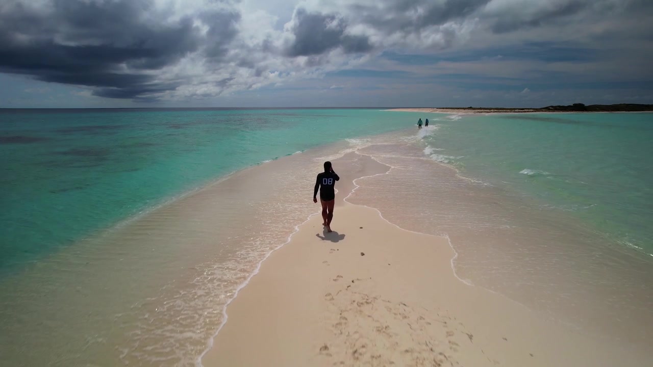 Enjoying a serene seaside stroll along a pristine white beach surrounded by turquoise waters in Los Roques Venezuela