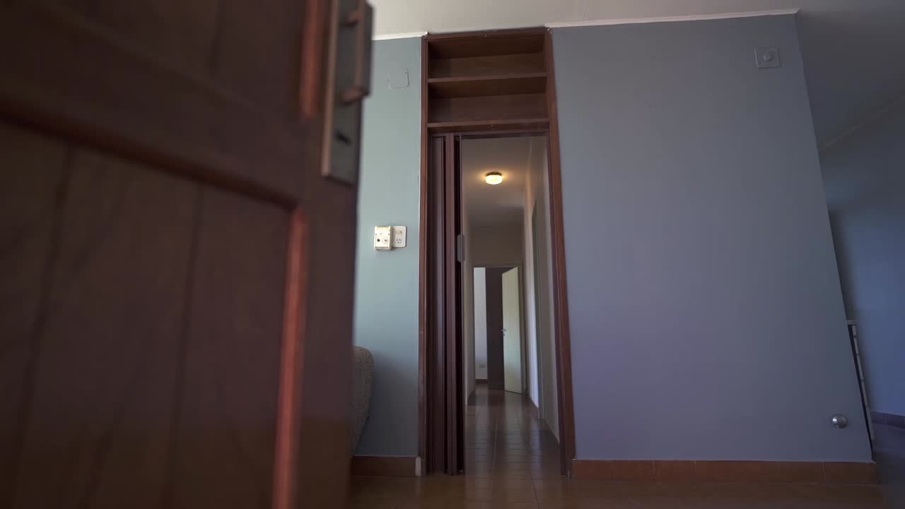 Low-angle shot invites viewers into Airbnb apartment living room, revealing wooden floor, grey walls, white ceiling, and welcoming couch. Perfect for rental listings.