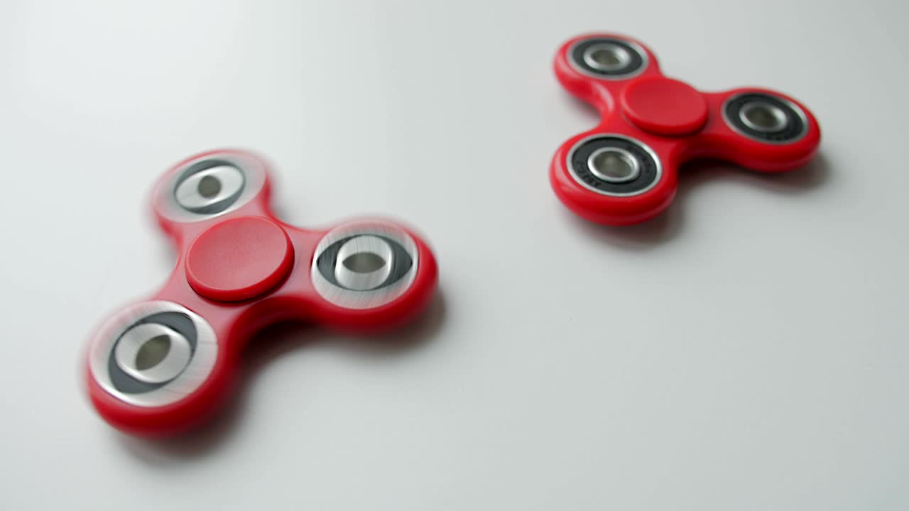 Close up of popular toy fidget spinner rotating over white background