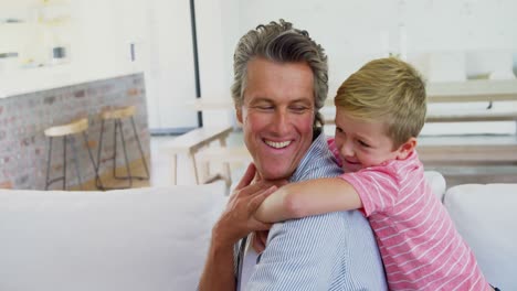 padre y hijo felices relajándose en el sofá en la sala de estar 4k