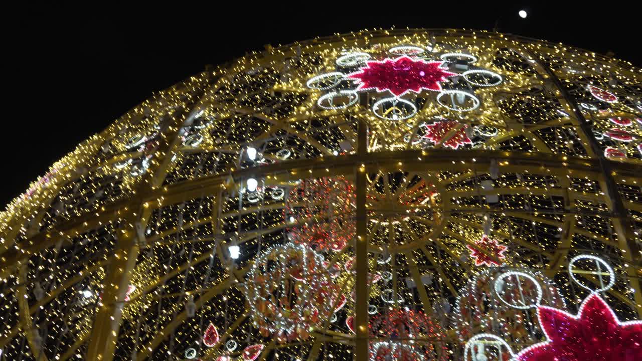 Colorful Christmas Lights Glittering All Over The Giant Christmas Ball Displayed At The Middle Of The Park - Close-up shot