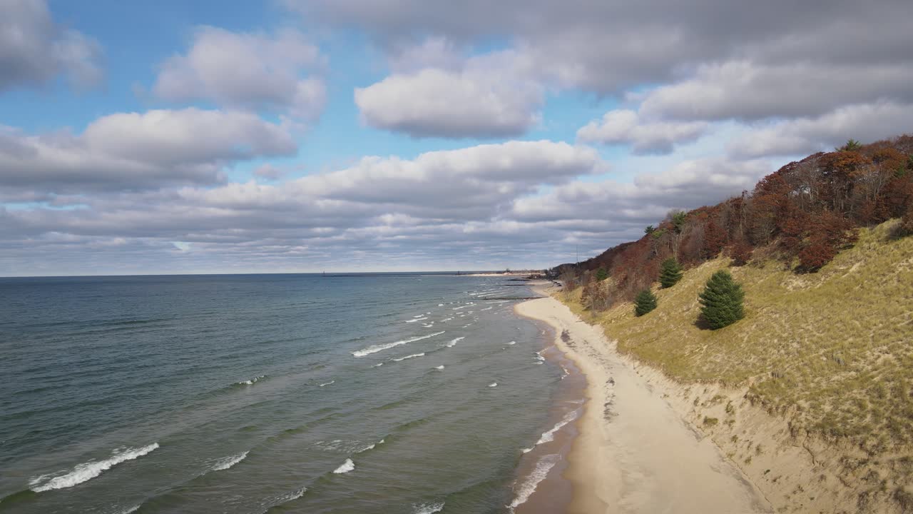 Ujęcie wzdłuż linii brzegowej Jeziora Michigan, pokazujące wydmy i delikatne fale