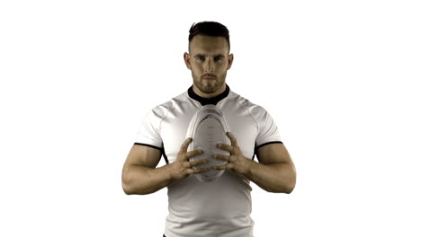 jugador de rugby serio sostiene la pelota de rugby