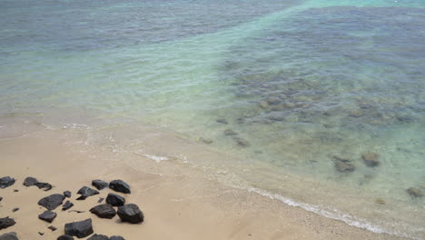 Calm-ocean-surface-and-idyllic-tropical-island-sandy-beach