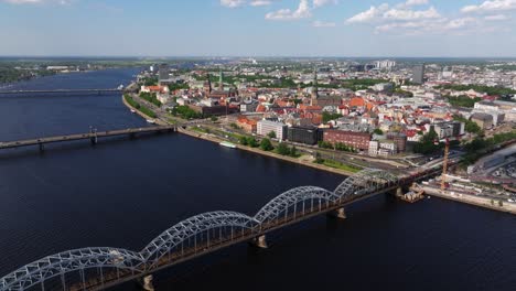 Cinemática-Que-Establece-Una-Vista-Aérea-Sobre-El-Río-Daugava-Con-Riga,-Letonia-Al-Fondo