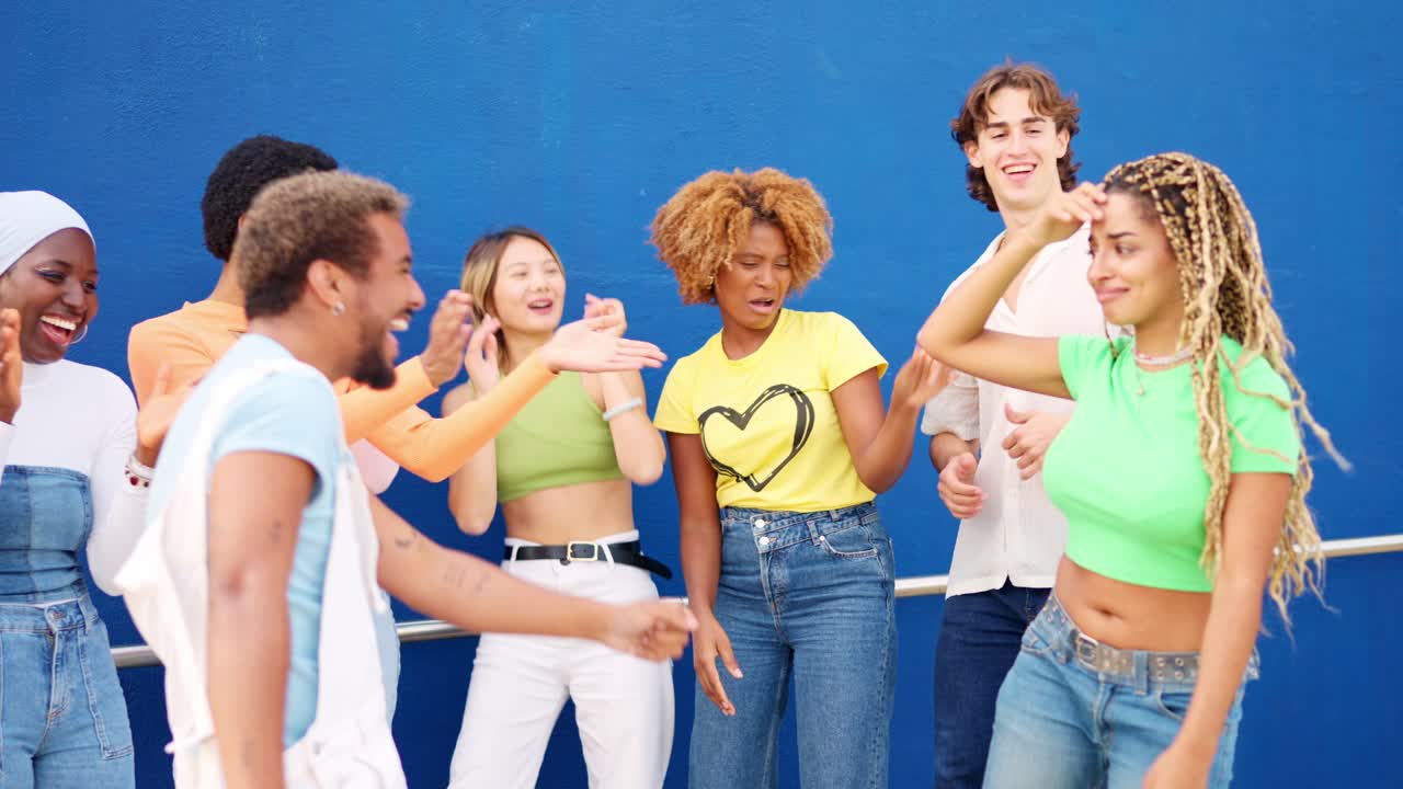 Latin friends dancing among multi-ethnic friends in an urban space