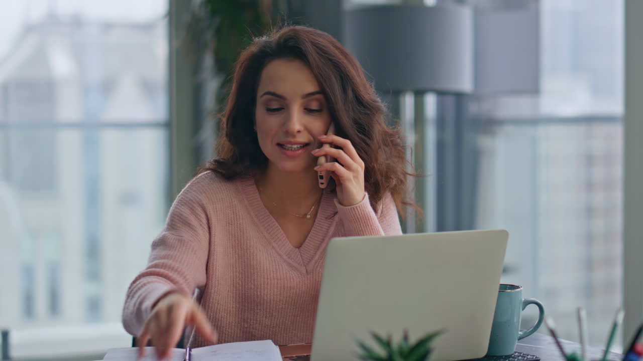 Donna felice che parla al cellulare in primo piano in un ufficio remoto. Signora che legge un contratto