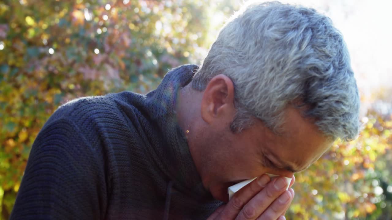 Man is blowing his nose