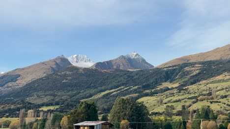 A serene mountain landscape with lush hills under a clear blue sky, captured in daylight
