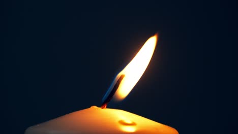 single big yellow candle flame lights and extinguish, isolated on a black background