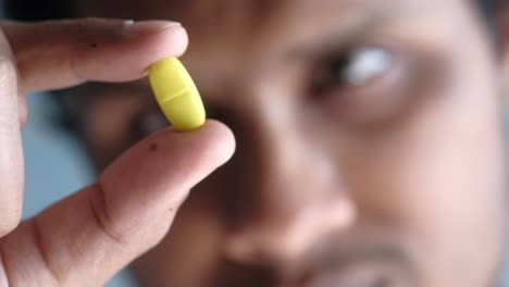 person holding a yellow pill