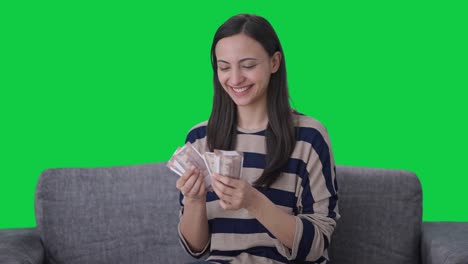 Happy-Indian-girl-counting-money-Green-screen