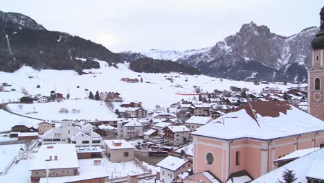 Panning-shot-of-a-church-in-a-snowbound-Tyrolean-village-in-the-Alps-in-Austria-Switzerland-Italy-Slovenia-or-an-Eastern-European-country