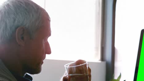 Male-executive-drinking-water-while-working-on-desktop-pc