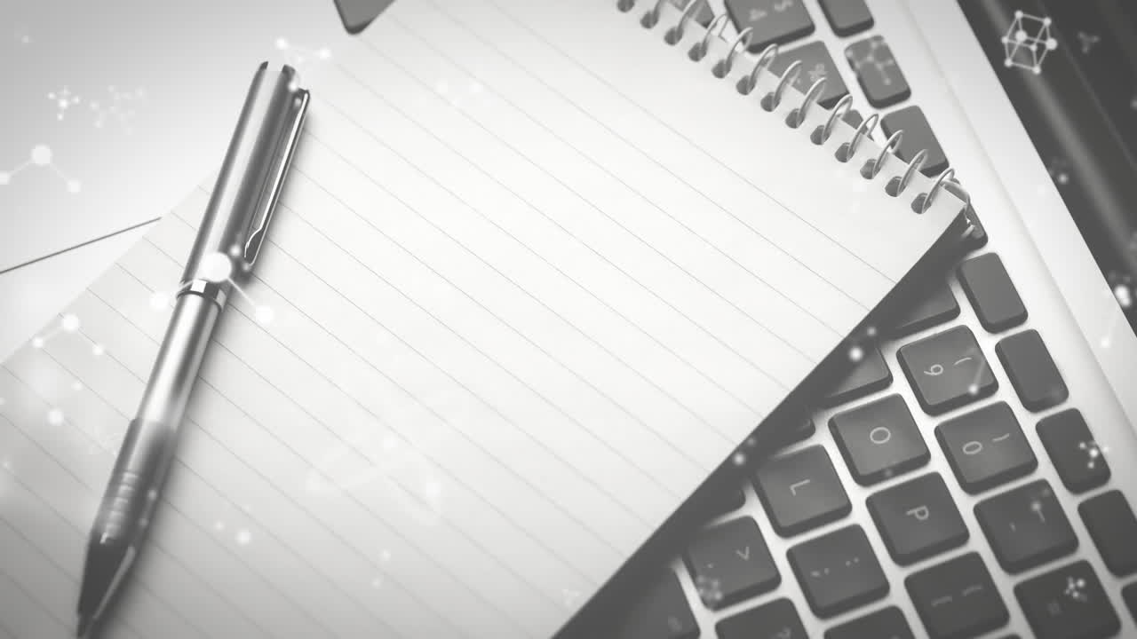 Animation of molecules moving over laptop, notebook and pen on desk
