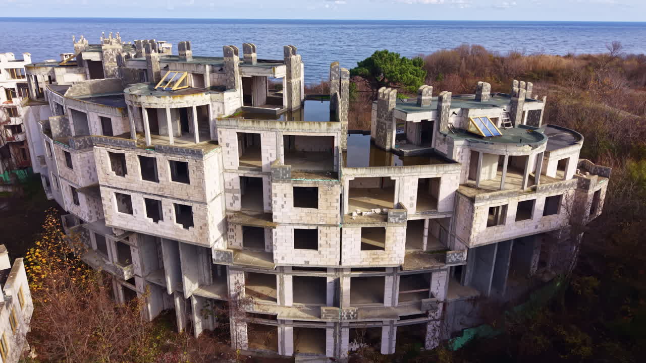 Esplorando un edificio costiero abbandonato, lasciato in rovina sotto un cielo nuvoloso, con la natura che si riappropria del suo spazio nel tempo.