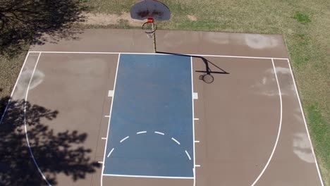 Drone-footage-of-Scottsdale-city-park,-basketball-court-pull-back-from-the-hoop