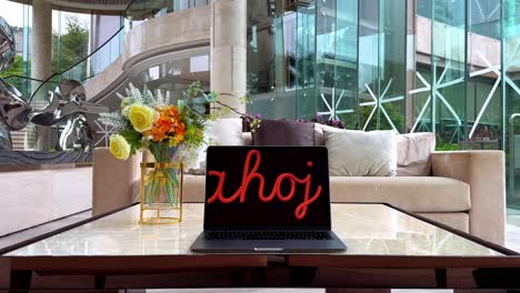 macbook displaying czech greeting "ahoj" on marble table inside a luxurious home