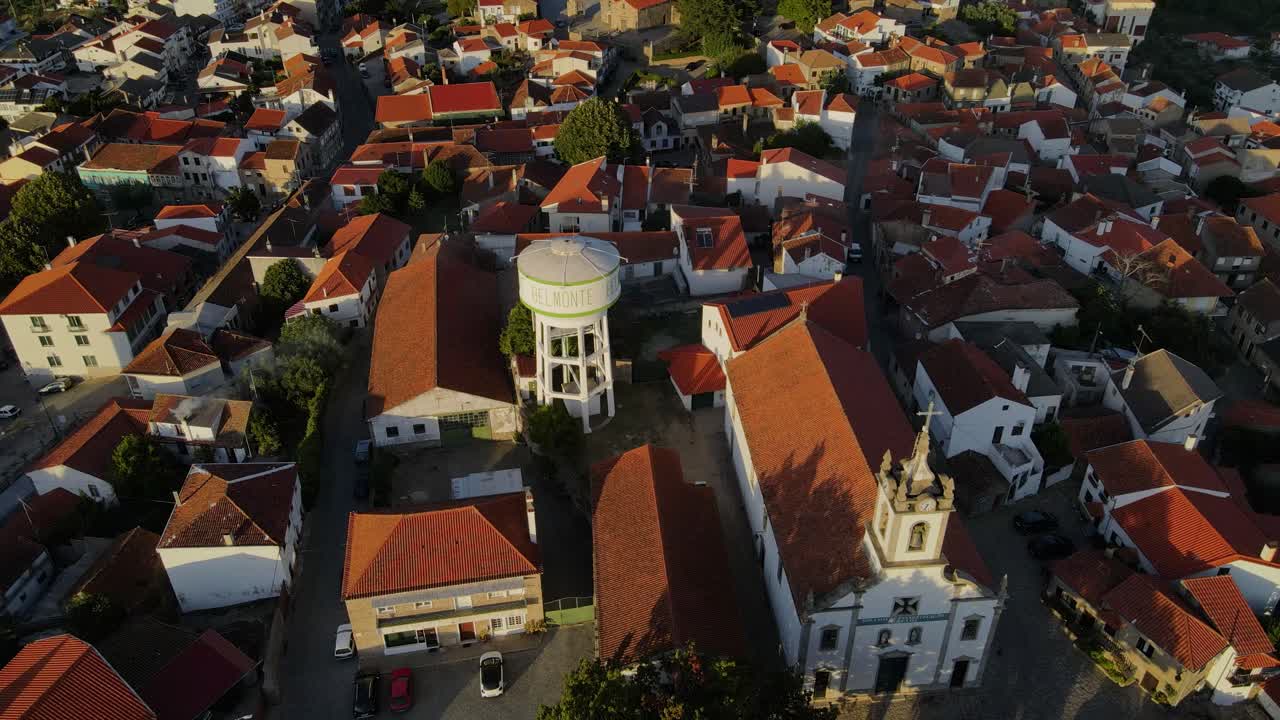 En drone tipper over et vandtårn for at vise Belmonte slot, mens fugle flyver forbi
