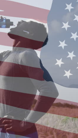 animation of american flag over african american man drinking water in mountains