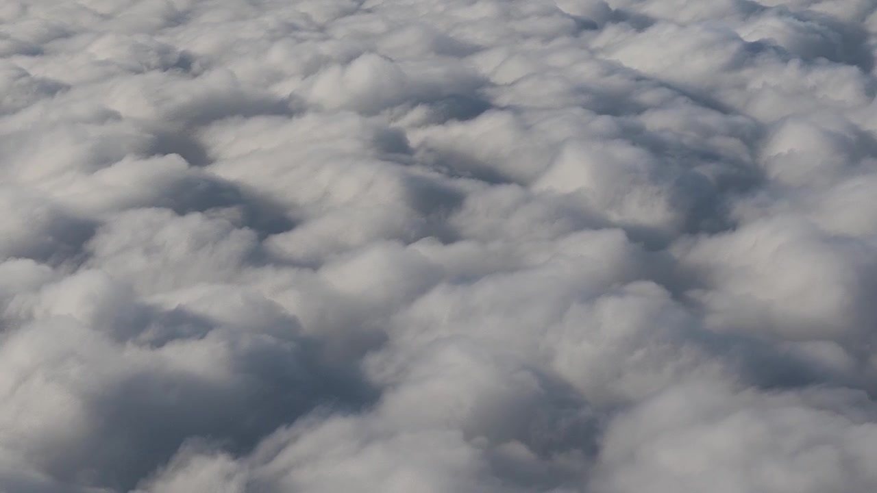 Natural handheld perspective gliding over a vast, multi-layered sea of clouds.