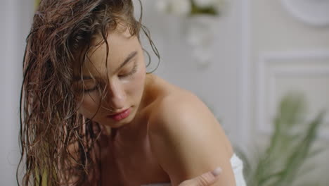 woman applying body lotion after the shower