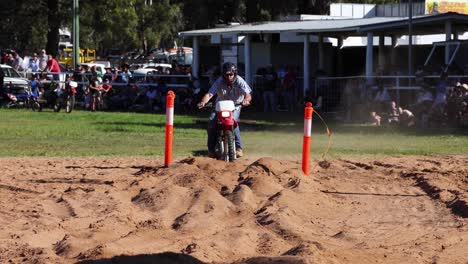 motorcycle jumping over dirt mound in race