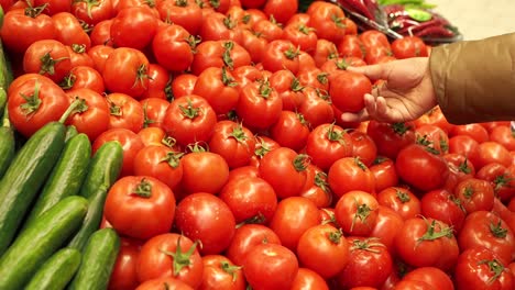 customer selecting tomatoes at a grocery store