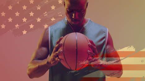 animation of american flag over focused african american male basketball player holding ball