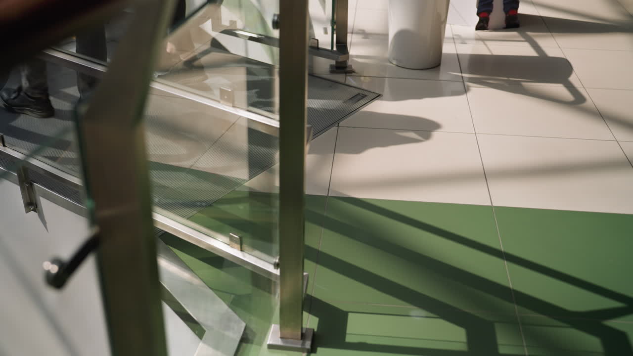 una escena dinámica que captura a la gente moviéndose en un centro comercial. el enfoque está en la mitad inferior de sus cuerpos, haciendo hincapié en el flujo de tráfico peatonal