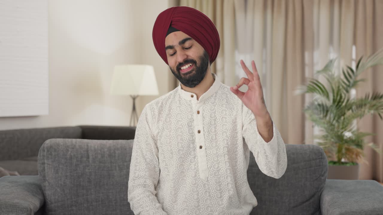 Uomo indiano Sikh felice che fa il segno dell'ok