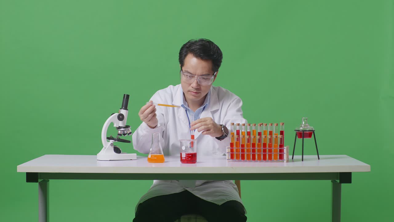 Asian Man Scientist Making Experiment With Test Tube And Screaming Goal Celebrating While Working On The Table With Microscope In The Green Screen Background Laboratory