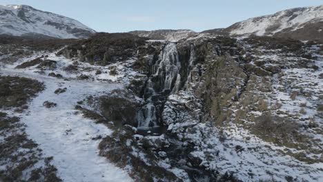 La-Cascada-Del-Velo-De-La-Novia-Con-Nieve-En-La-Isla-De-Skye,-Escocia,-Capturando-La-Serena-Belleza-De-La-Naturaleza,-Vista-Aérea.