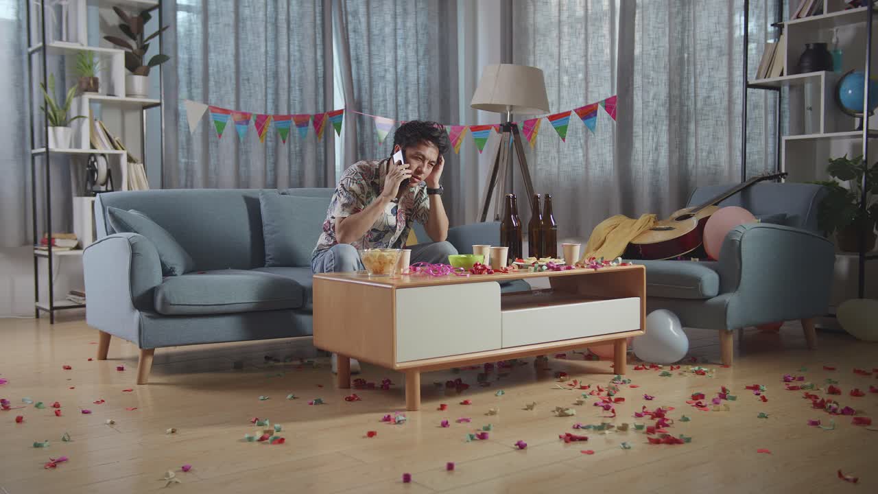 hombre al teléfono en una fiesta desordenada