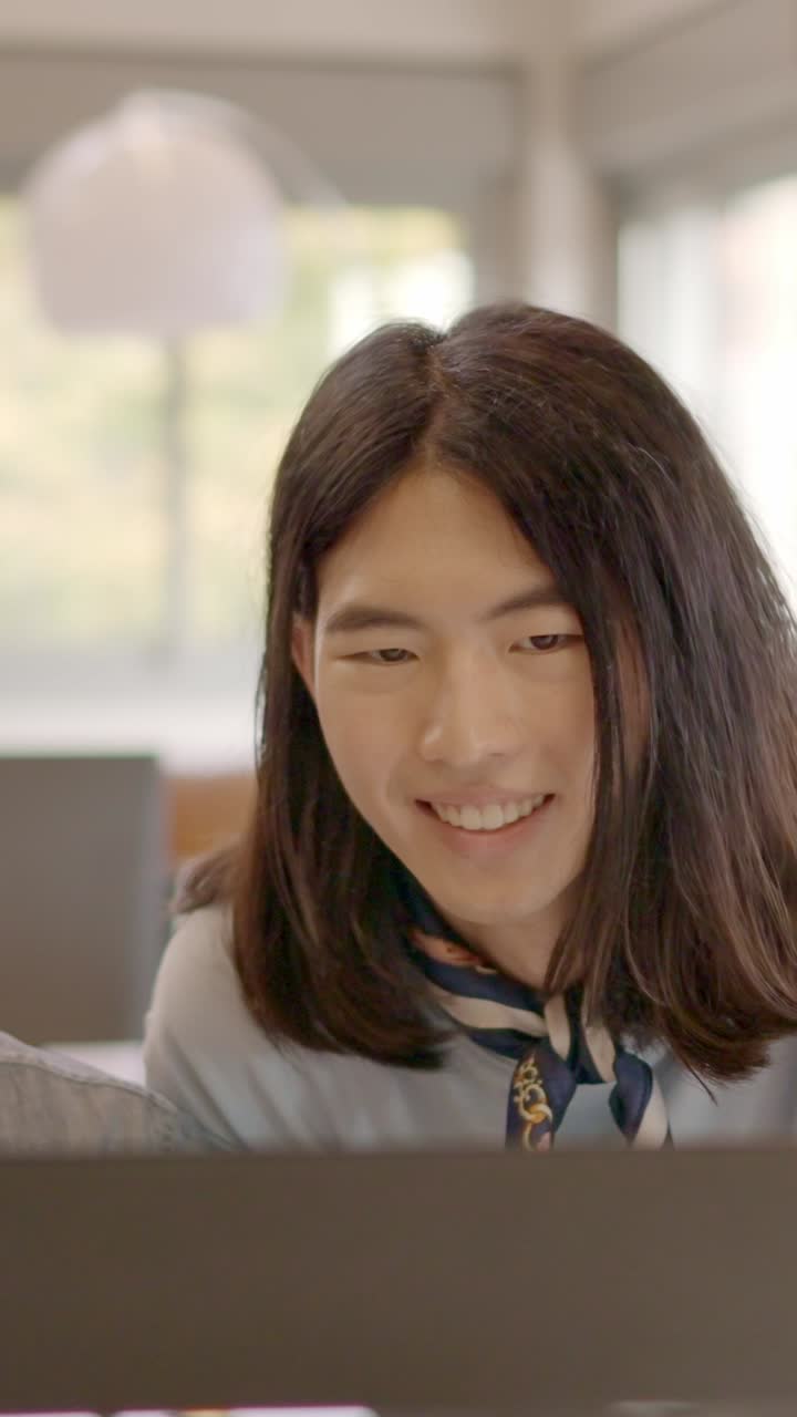 Multi-ethnic coworkers using computer and talking in the office