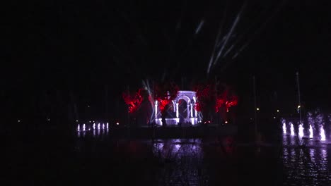 gorgeous water colorful light show in kadriorg park during evening in slow motion. light beams illuminate a house in the middle and water fountains shoot up at different time with different colors.