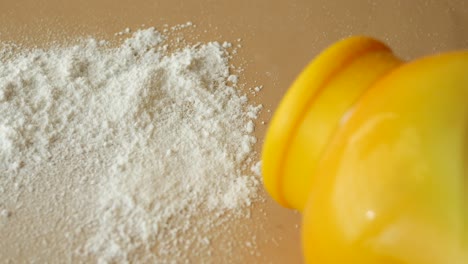 baby powder scattered on a surface with a yellow container