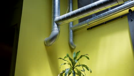 slow tilting shot of a couple of chairs sat beside green foliage in an office