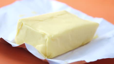 slice of a butter on a paper on table