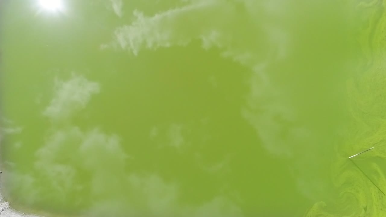 retirada aérea que revela un depósito de agua artificial verde con bajos niveles de agua.