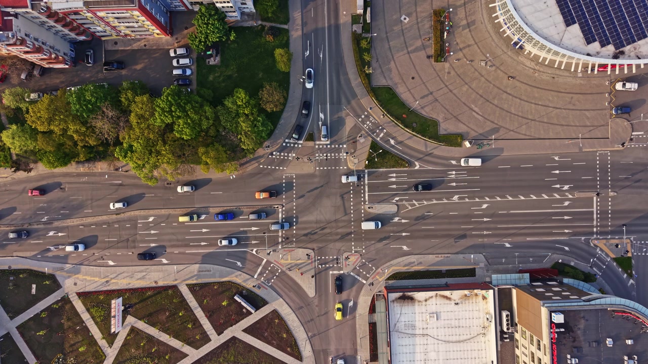 Busy urban intersection in the city with cars and trees on a clear day during afternoon hours