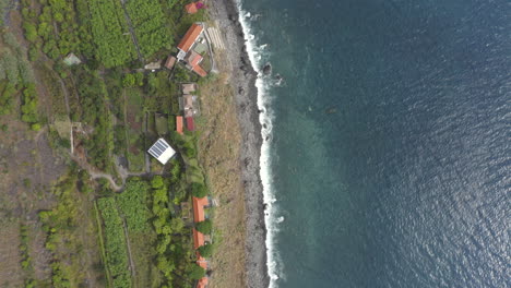 vista panorámica del pequeño pueblo agrícola de fajã dos padres en la isla de madeira, portugal - toma aérea de drones