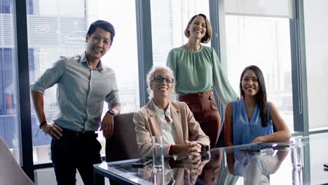smiling business team posing together around conference table in modern office