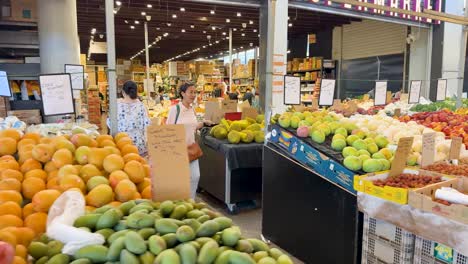 los compradores exploran diversas frutas en la plaza de inala