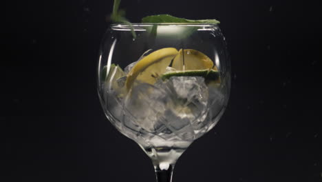 limones de menta caen cubos de hielo vaso de vino de cerca.